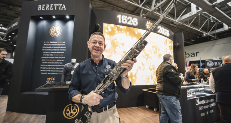 A Beretta representative presenting a shotgun in front of the 500th anniversary display at the Great British Shooting Show