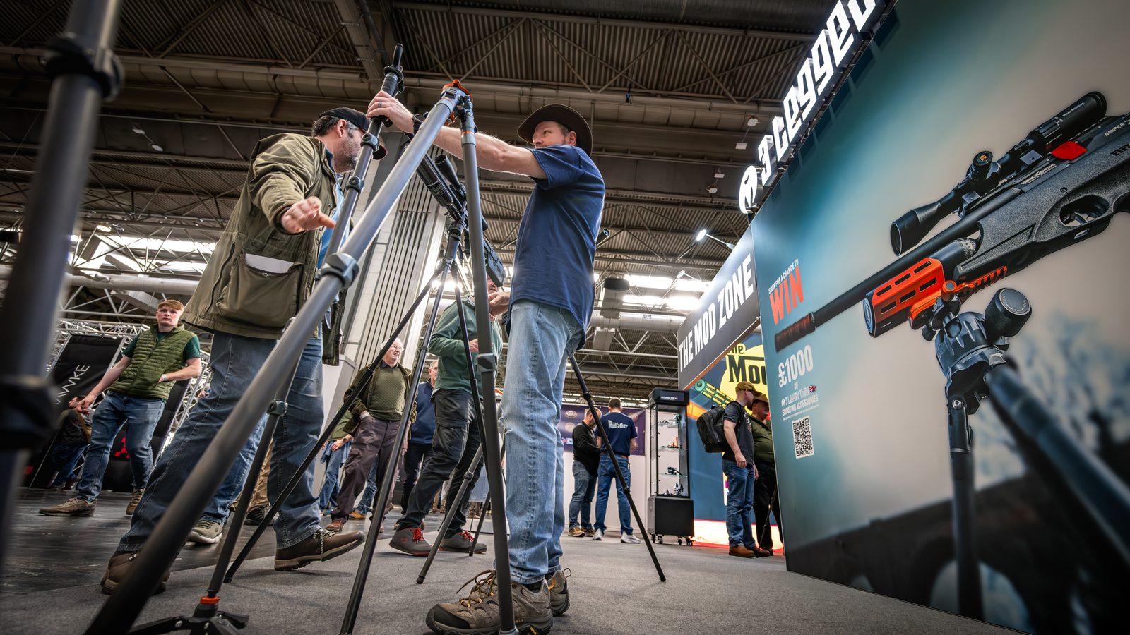 Visitors handling tactical tripods on the 3 Legged Thing stand at the Great British Shooting Show