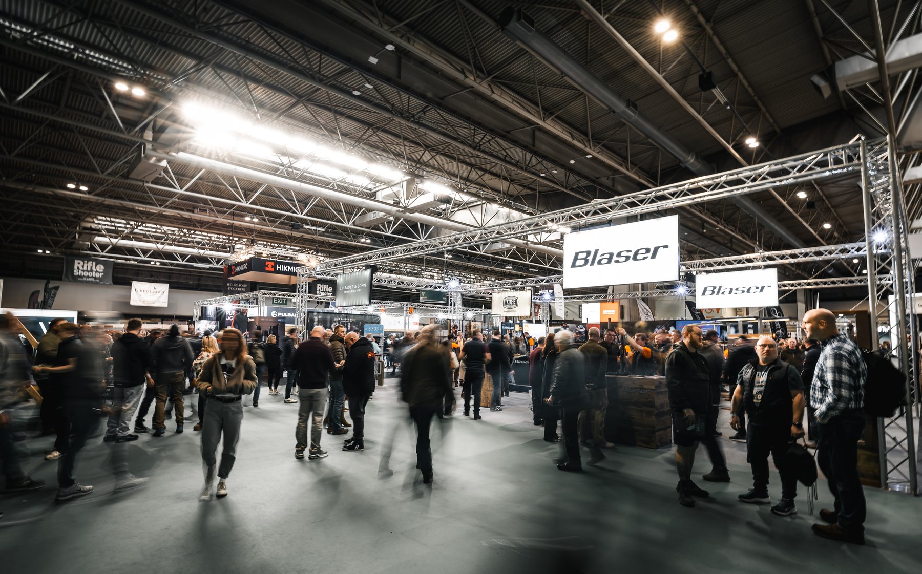Visitors in the exhibition hall at the Great British Shooting Show with the Blaser stand signage overhead