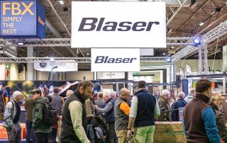 Crowds on the Blaser stand beneath the Blaser signage at the Great British Shooting Show