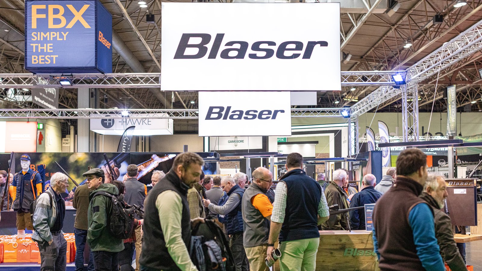 Crowds on the Blaser stand beneath the Blaser signage at the Great British Shooting Show