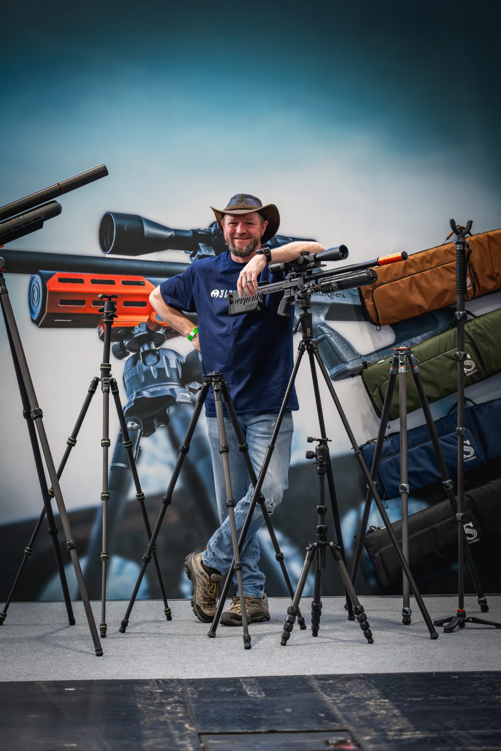 Danny Lenihan with a moderated rifle mounted on a 3 Legged Thing tactical tripod on the show stand