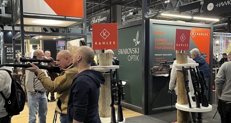 The Swarovski Optik and Kahles stand at the 2026 British Shooting Show, with visitors handling rifles and optics