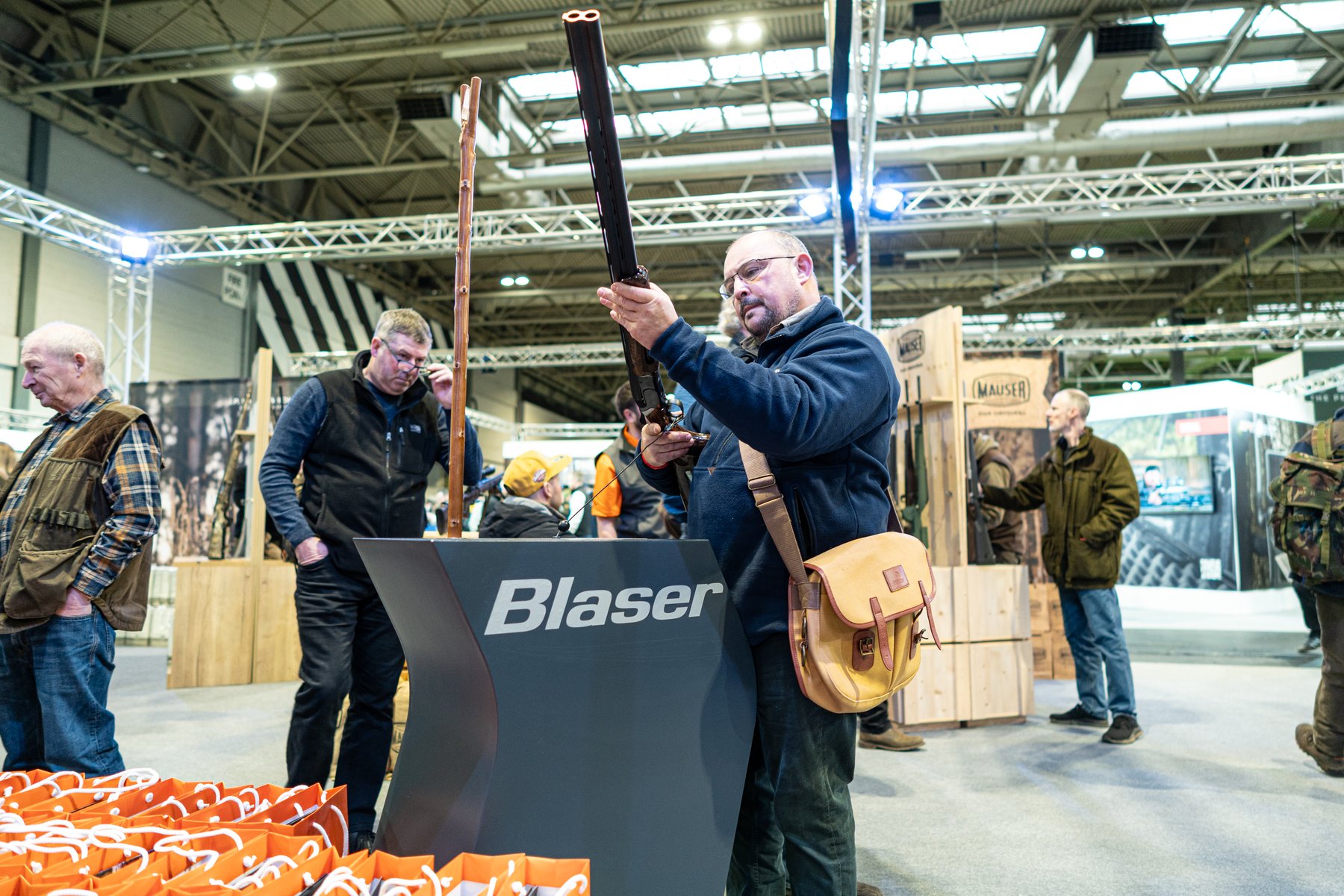 A visitor looking down the barrels of an over-and-under shotgun on the Blaser stand