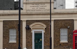 The front of the London Proof House on Commercial Road, with a red telephone box beside it